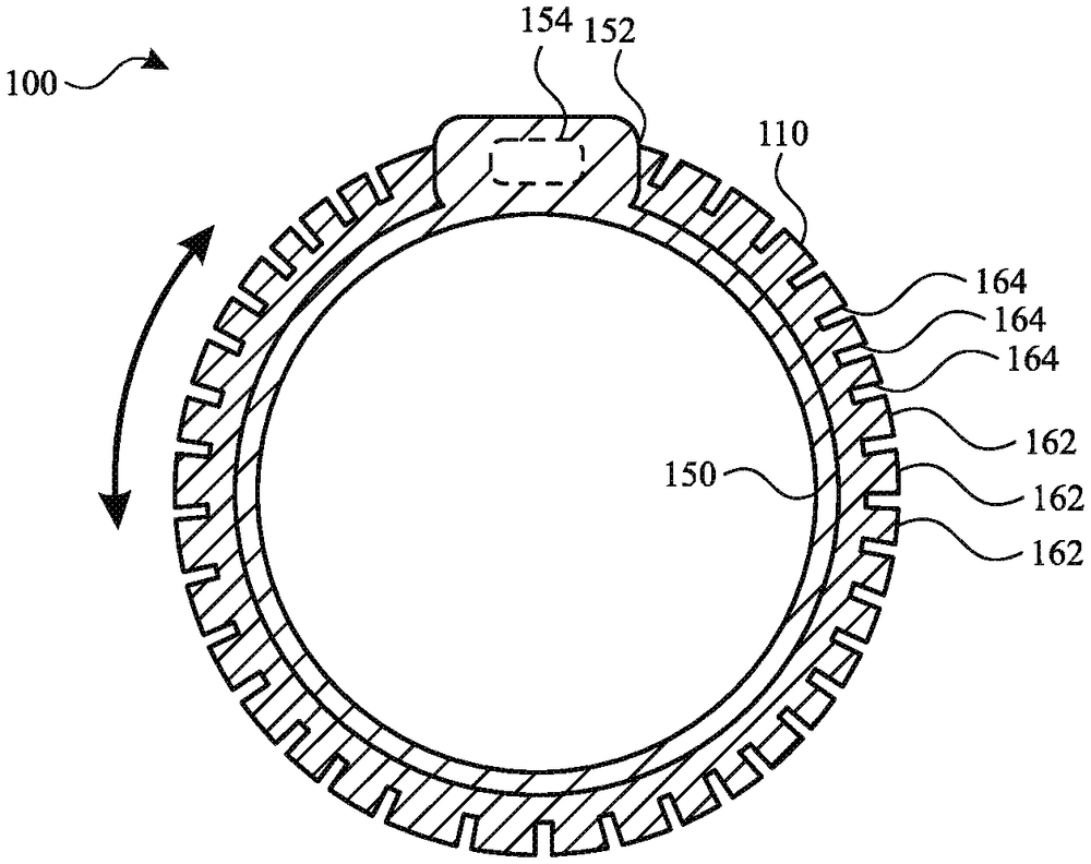 A ring seen from the front, its outer edge cut into a band of small square teeth, with a raised block at the top and a curved arrow showing it turning both ways